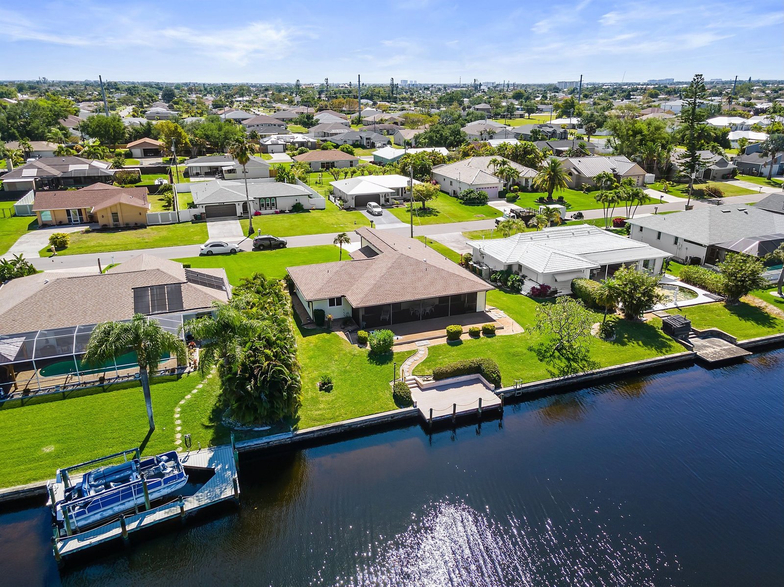 A pontoon boat docked on a Cape Coral canal