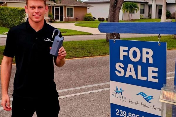 Brayden Milner in front of a Cape Coral home with a Milner Team For Sale sign